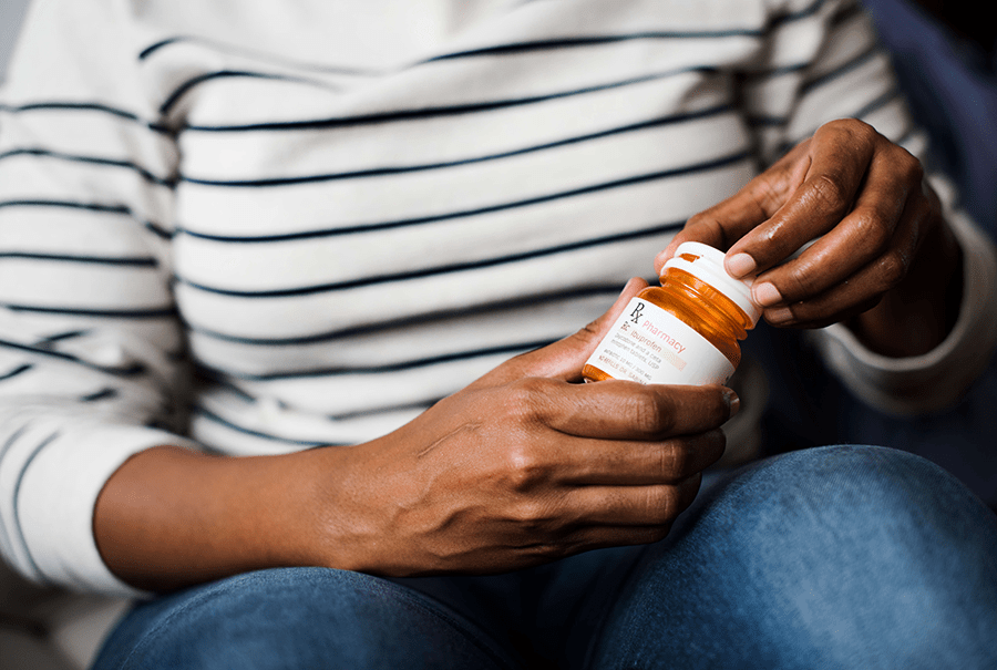 Woman opens pill bottle for medication 