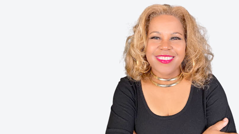 head shot of Sybil Wilkes, a Black woman smiling and wearing a black top and a silver necklace head shot of Sybil Wilkes, a Black woman smiling and wearing a black top and a silver necklace