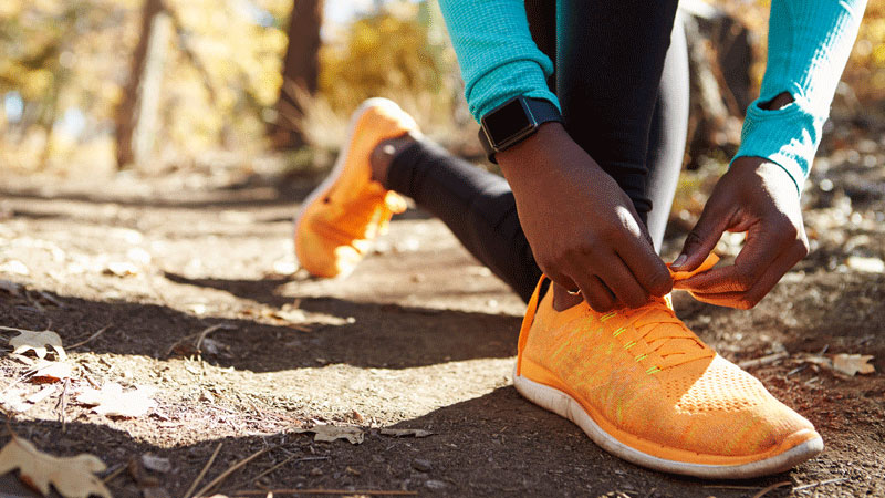 Female African American runner tying sneaker Female African American runner tying sneaker