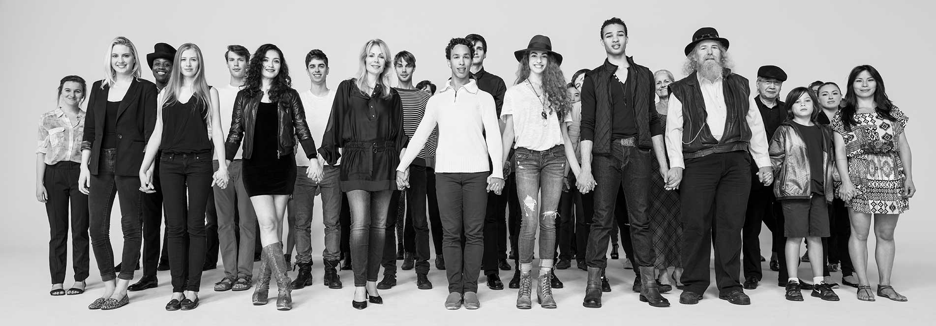 group of people holding hands and standing while looking directly at the camera