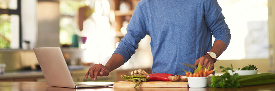 Man cooking recipe on laptop Man cooking recipe on laptop